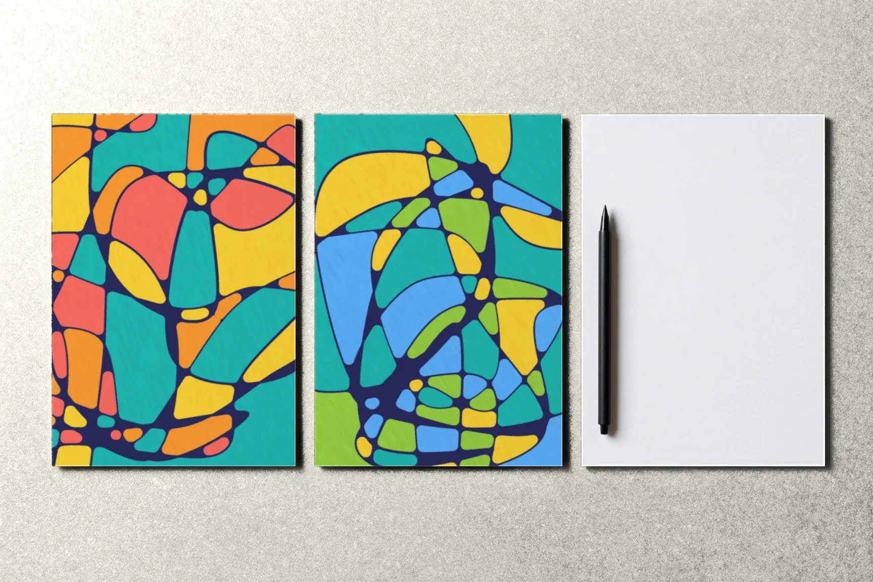 Two finished drawings and a blank sheet for the next one, a pen lying on it.