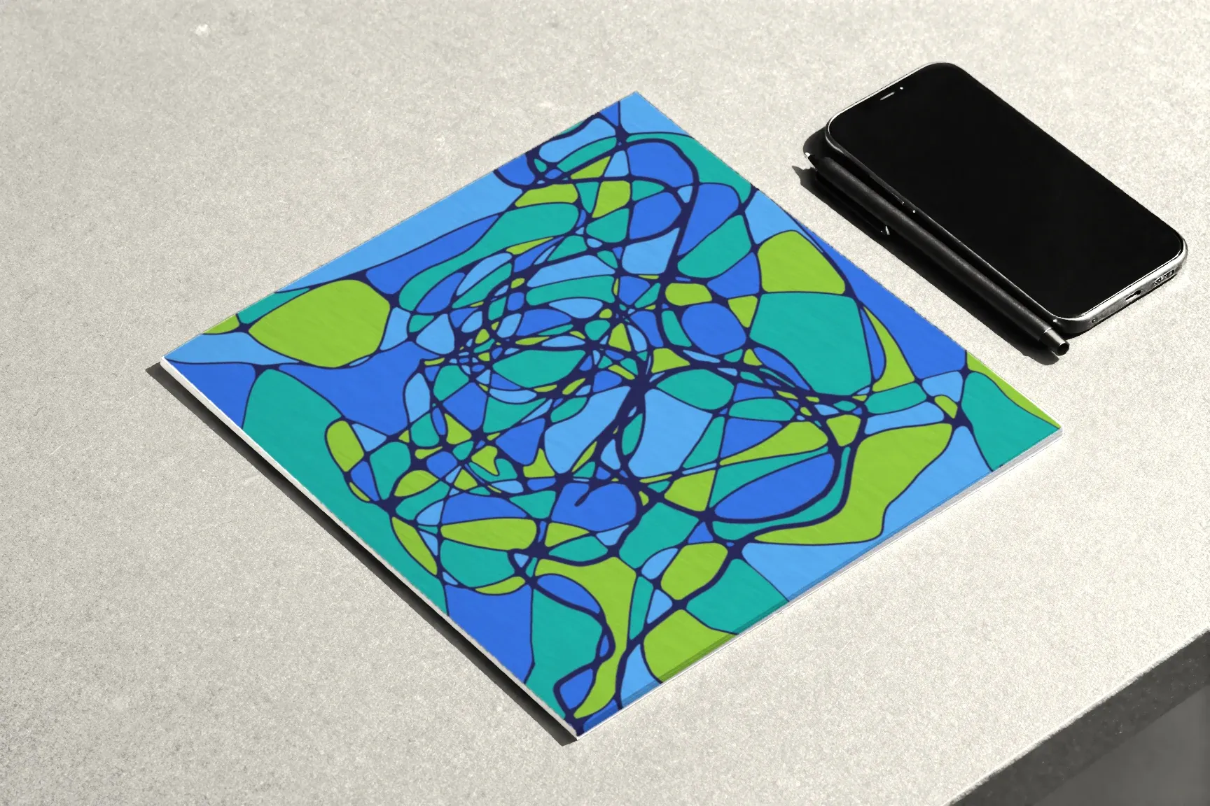 The author’s composition in blues and greens, a phone lying face down and a fine-liner beside it.