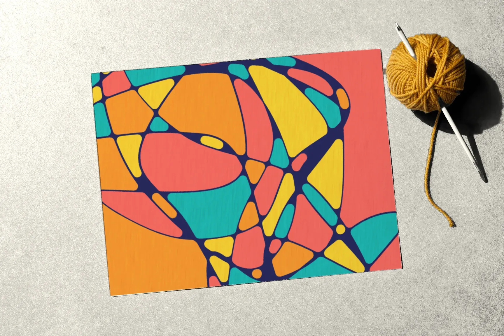 A coloured drawing next to a ball of mustard yarn with knitting needles.